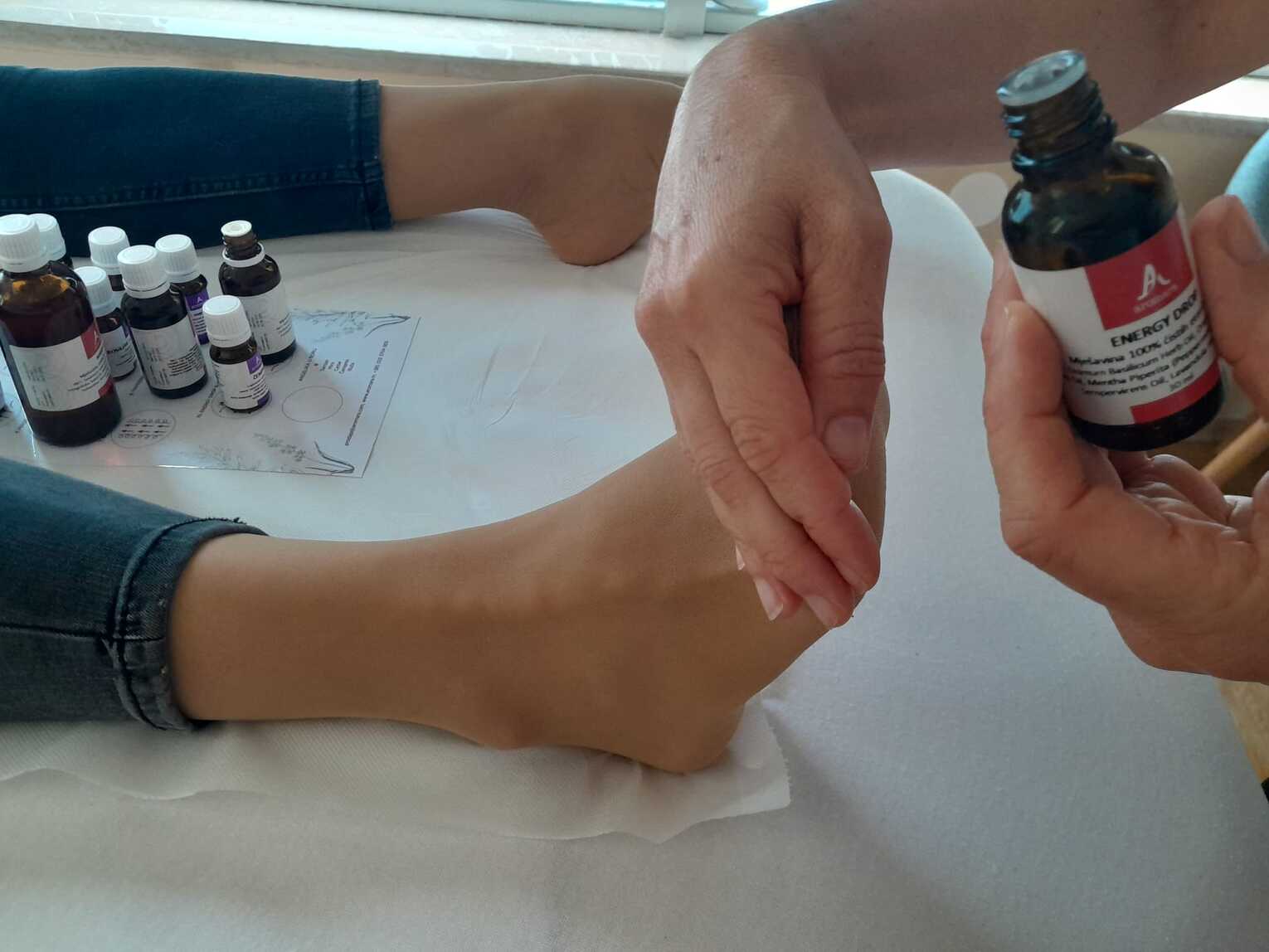 masaža desnog stopala i raindrop witaflex esencijalno ulje u ruci masažera